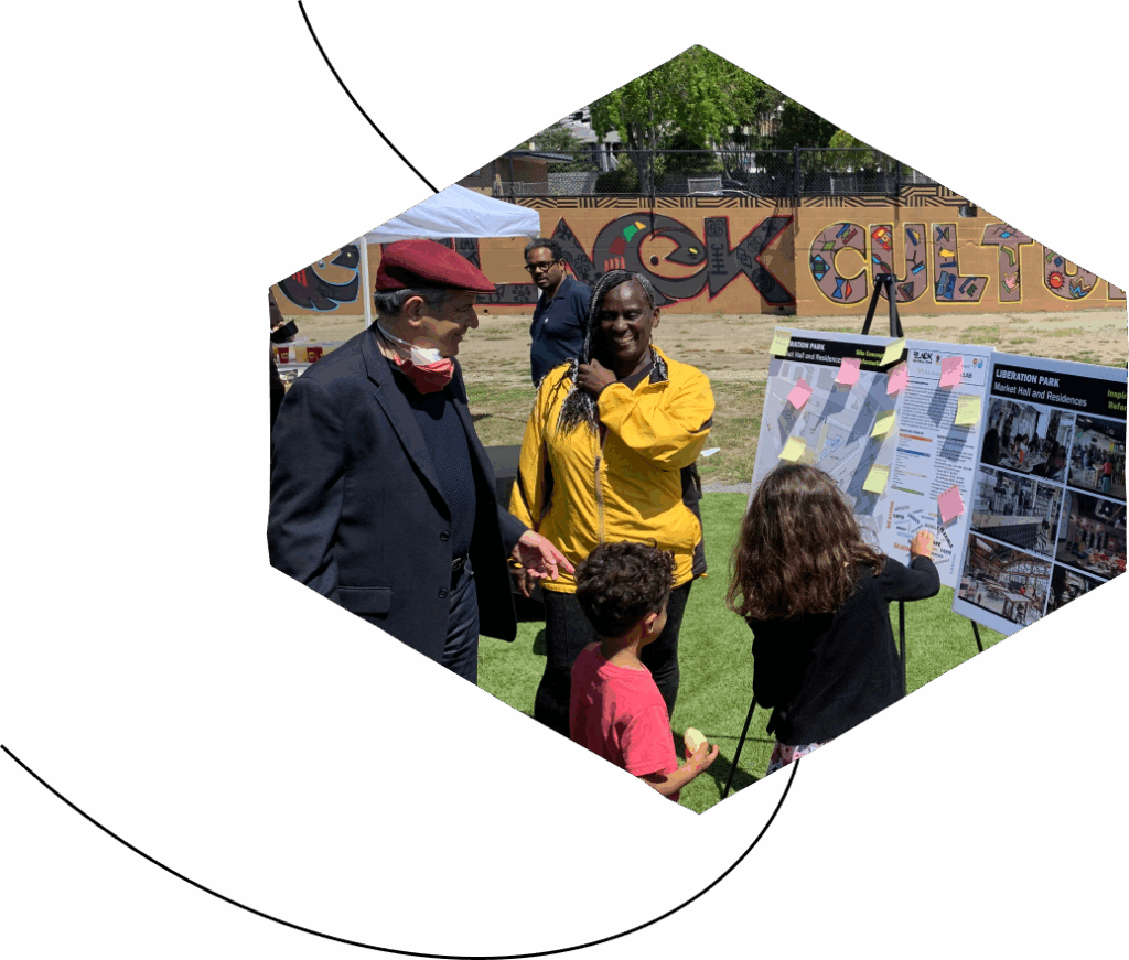A light-skinned man with a red cap and a dark-skinned woman smile as two kids put on post-its on a poster in a park